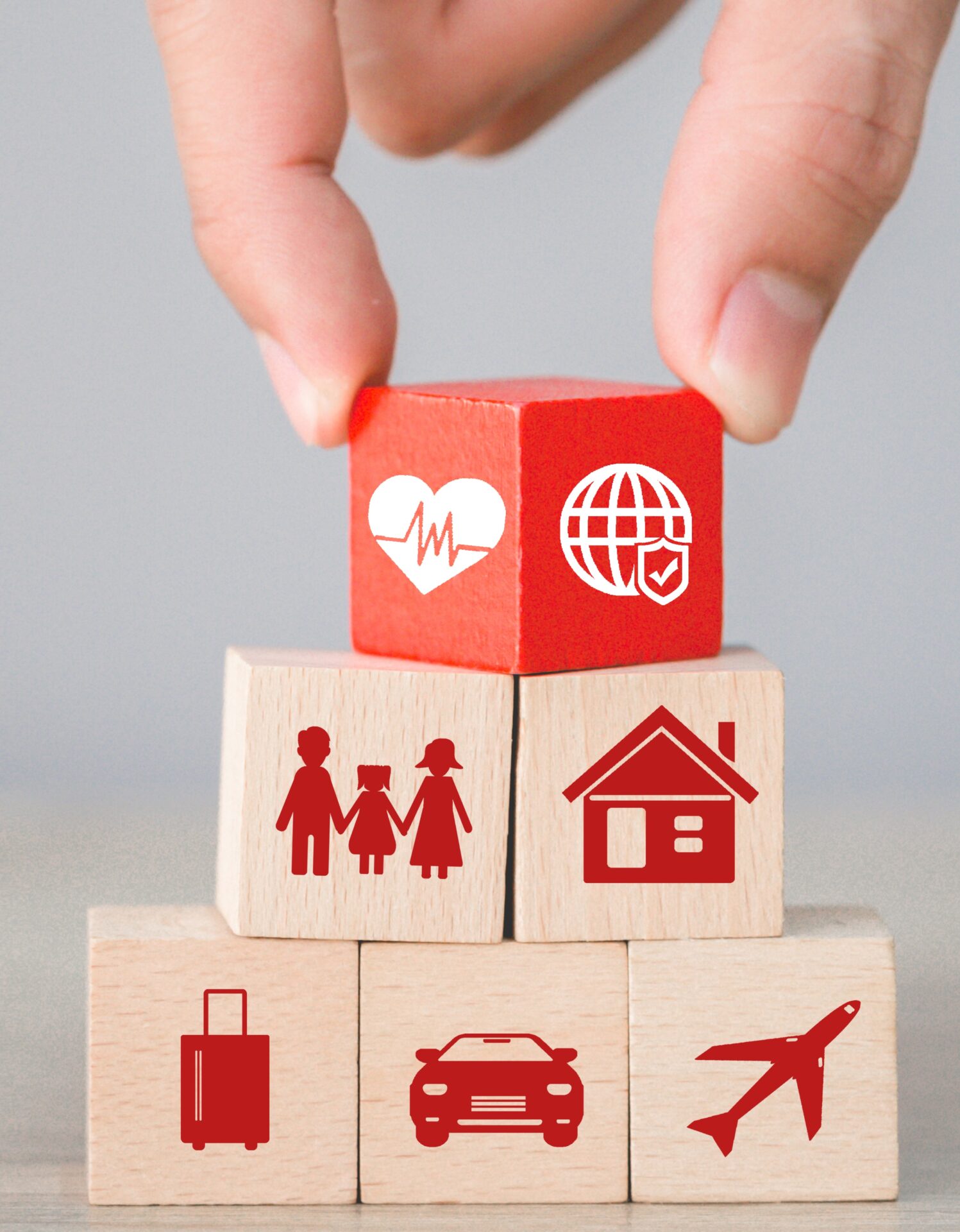 Hand arranging wood block stacking with icon insurance: car,
