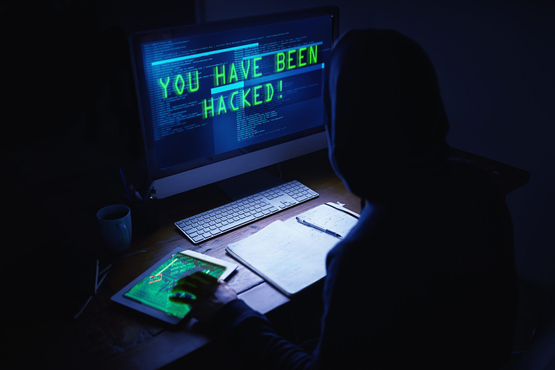 Dark deeds in the dead of night. an unidentifiable hacker using a computer late at night.